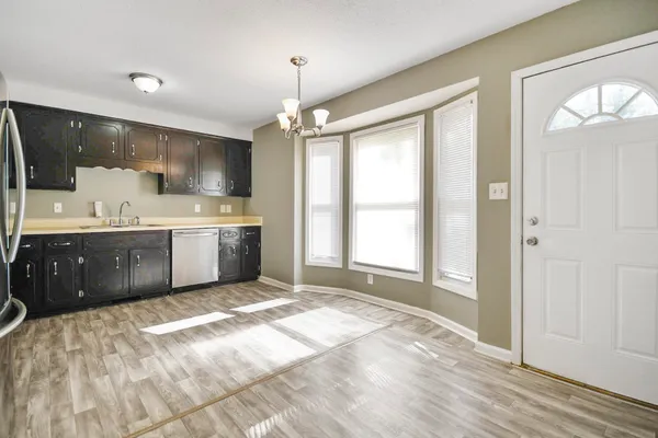 a large kitchen with a stove a sink dishwasher and a refrigerator