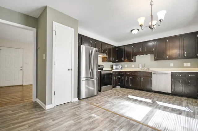 a kitchen with kitchen island a sink stainless steel appliances and cabinets