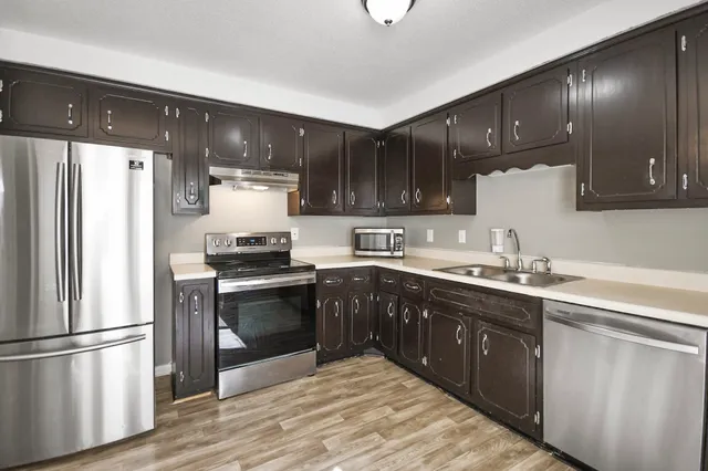 a kitchen with a sink refrigerator and cabinets