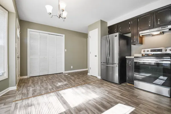 a kitchen with a refrigerator and a stove top oven