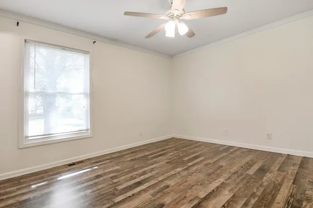 wooden floor in an empty room with a window