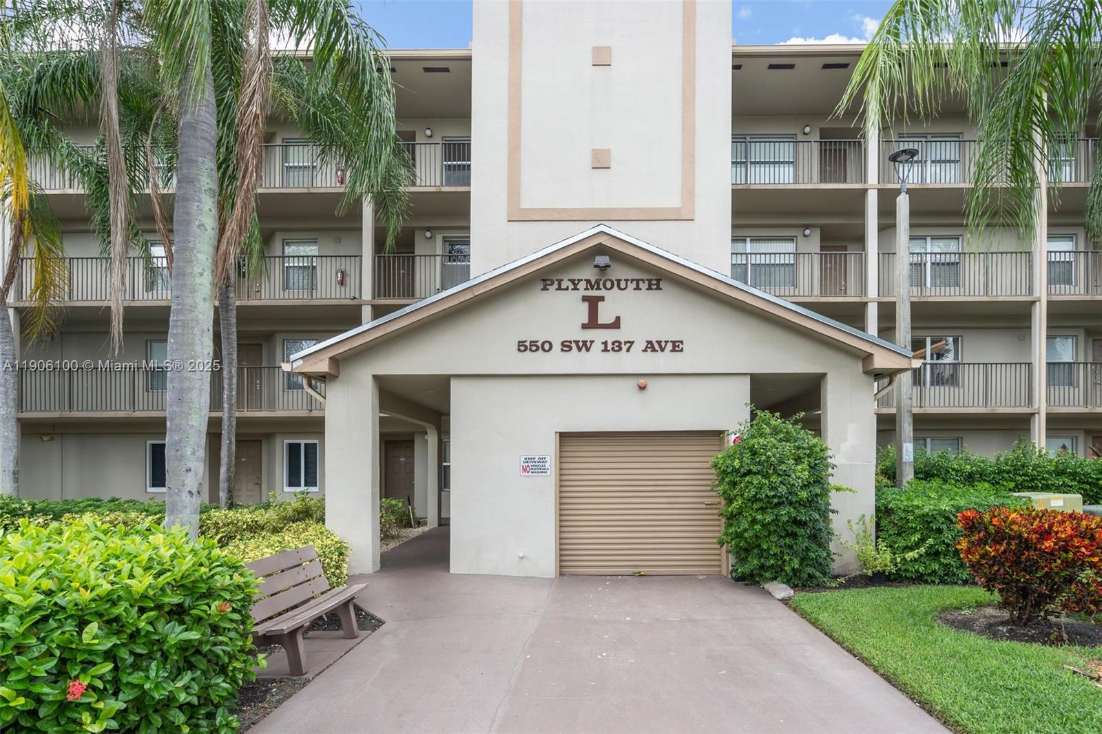 550 Southwest 137th Avenue, Unit 208L Pembroke Pines, FL 33027 - Photo 16 of 18 front view of a house with a yard and potted plants