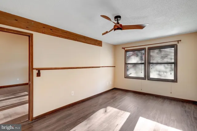 a view of a big room with wooden floor and windows