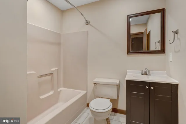 a bathroom with a toilet a sink a mirror and vanity