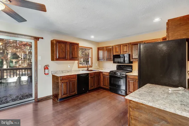 a kitchen with stainless steel appliances granite countertop a refrigerator stove top oven and sink