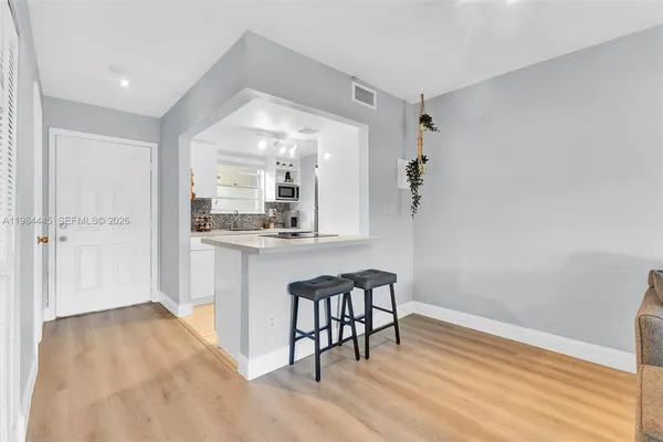 a view of a hallway with wooden floor and a bathroom