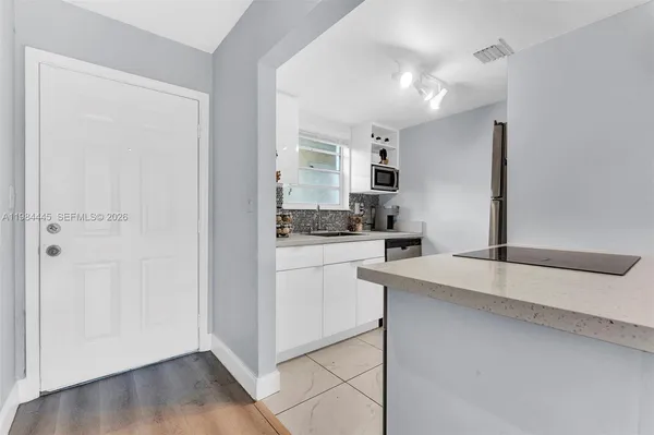 a kitchen with a sink cabinets and wooden floor