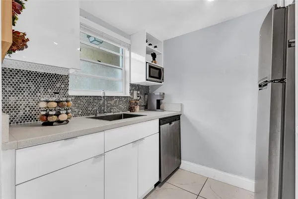 a kitchen with stainless steel appliances a sink and a refrigerator