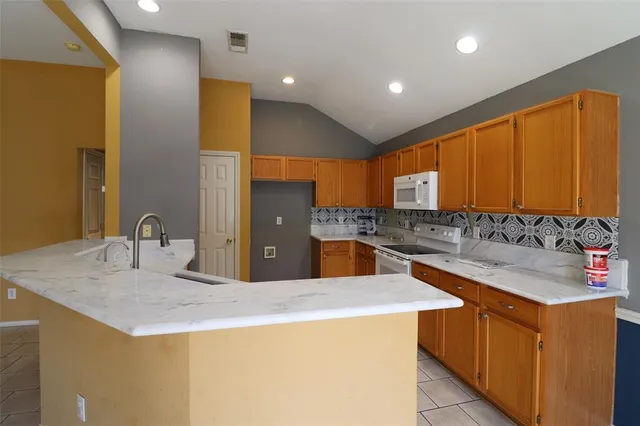 a kitchen with stainless steel appliances kitchen island granite countertop a sink and cabinets