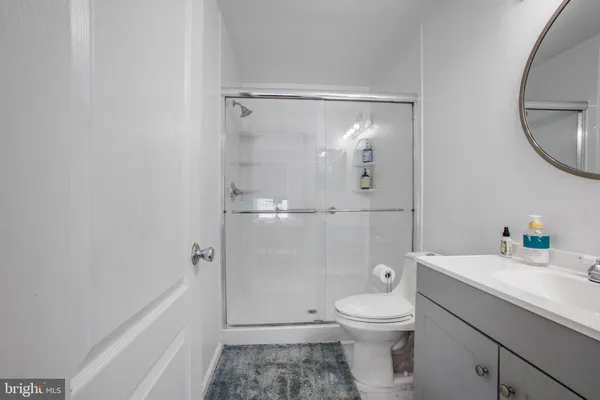 a bathroom with a granite countertop toilet a sink and a mirror