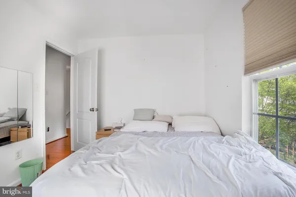 a bedroom with a bed and a large window