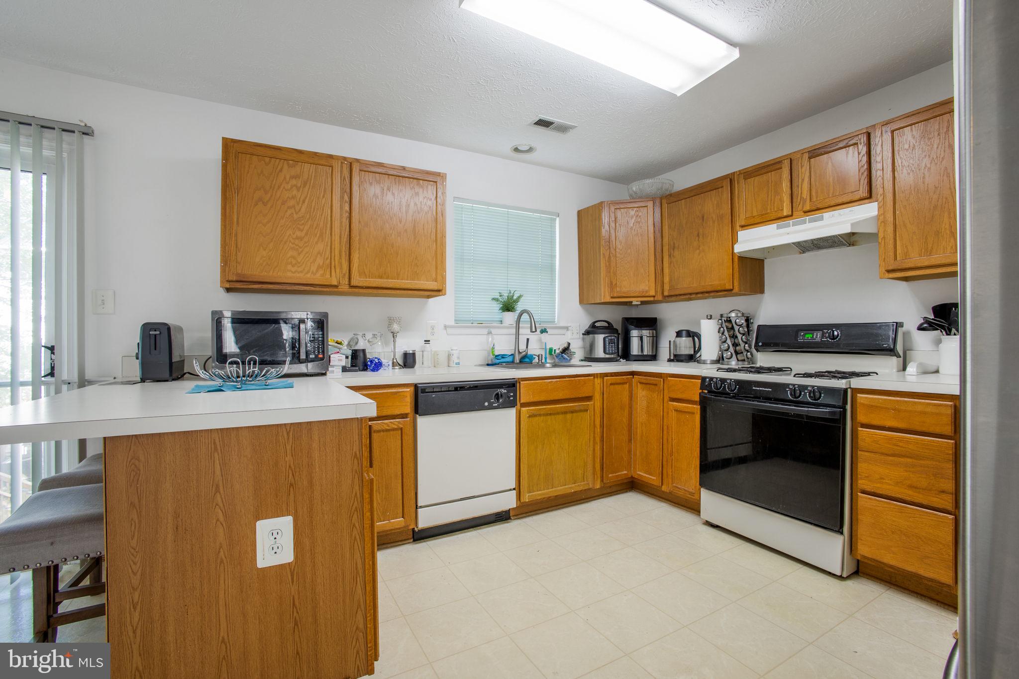 9820 Berrywood Court Bowie, MD 20721 - Photo 42 of 43 a kitchen with stainless steel appliances granite countertop a sink stove and refrigerator