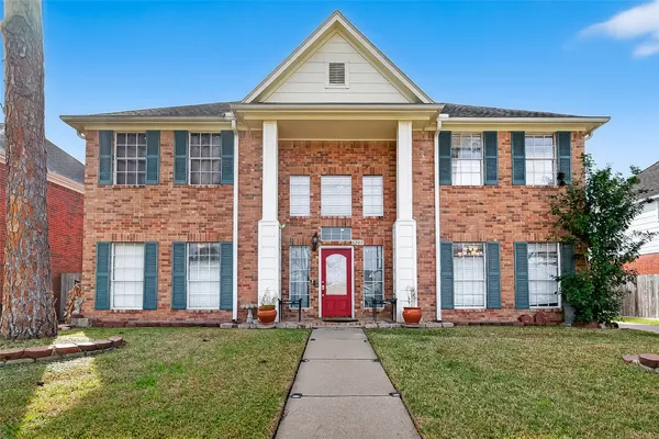 front view of a brick house with a yard