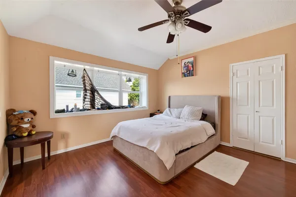 a bedroom with a bed and wooden floor