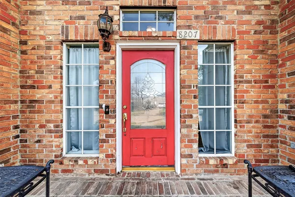 a front view of a building with a red door and a shower