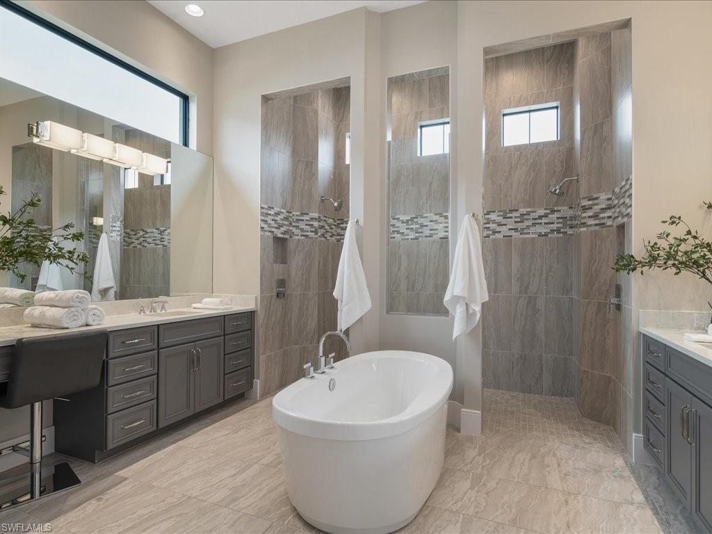 16337 Corsica Way Naples, FL 34110 - Photo 14 of 47 a bathroom with a bathtub shower sink and mirror