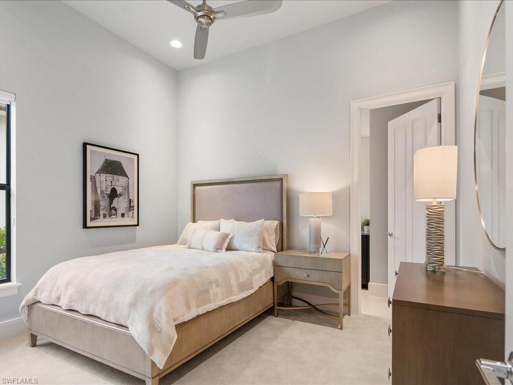 16337 Corsica Way Naples, FL 34110 - Photo 17 of 47 a bedroom with a bed and a chandelier