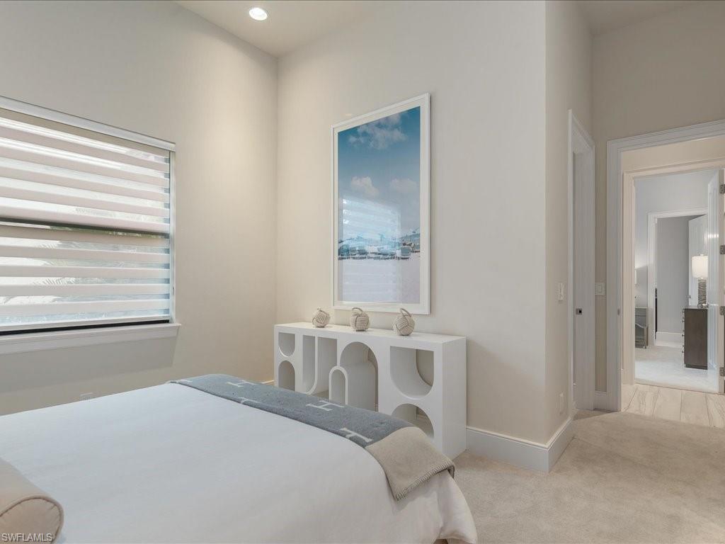 16337 Corsica Way Naples, FL 34110 - Photo 20 of 47 a bedroom with a bed and a table