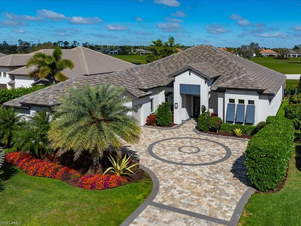 16337 Corsica Way Naples, FL 34110 - Photo 2 of 47 a view of a white house with a big yard and potted plants
