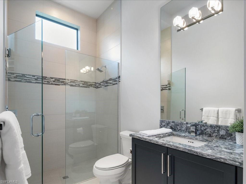 16337 Corsica Way Naples, FL 34110 - Photo 21 of 47 a bathroom with a granite countertop sink toilet and shower