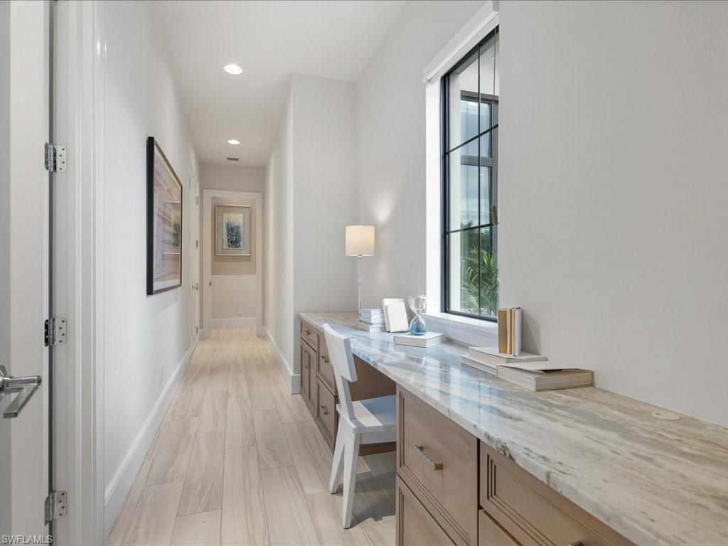 16337 Corsica Way Naples, FL 34110 - Photo 22 of 47 a hallway with sink and mirror