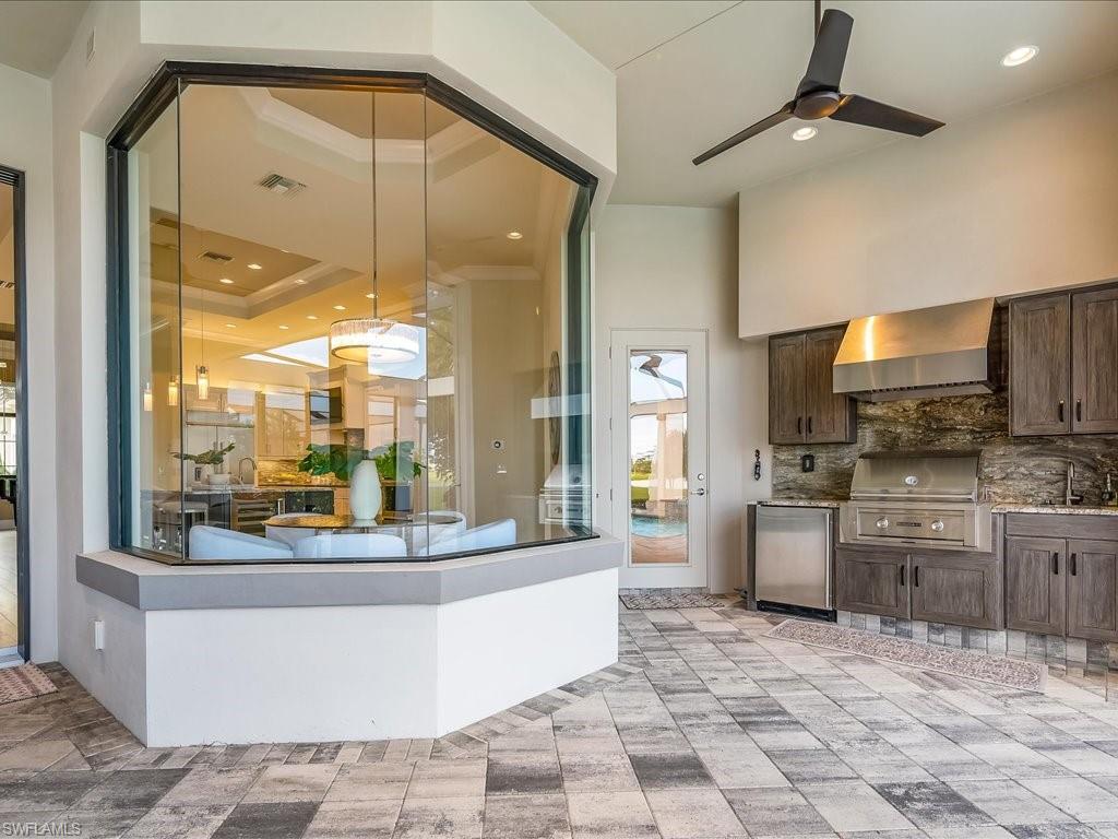 16337 Corsica Way Naples, FL 34110 - Photo 28 of 47 a view of a kitchen with a large window cabinets and stainless steel appliances