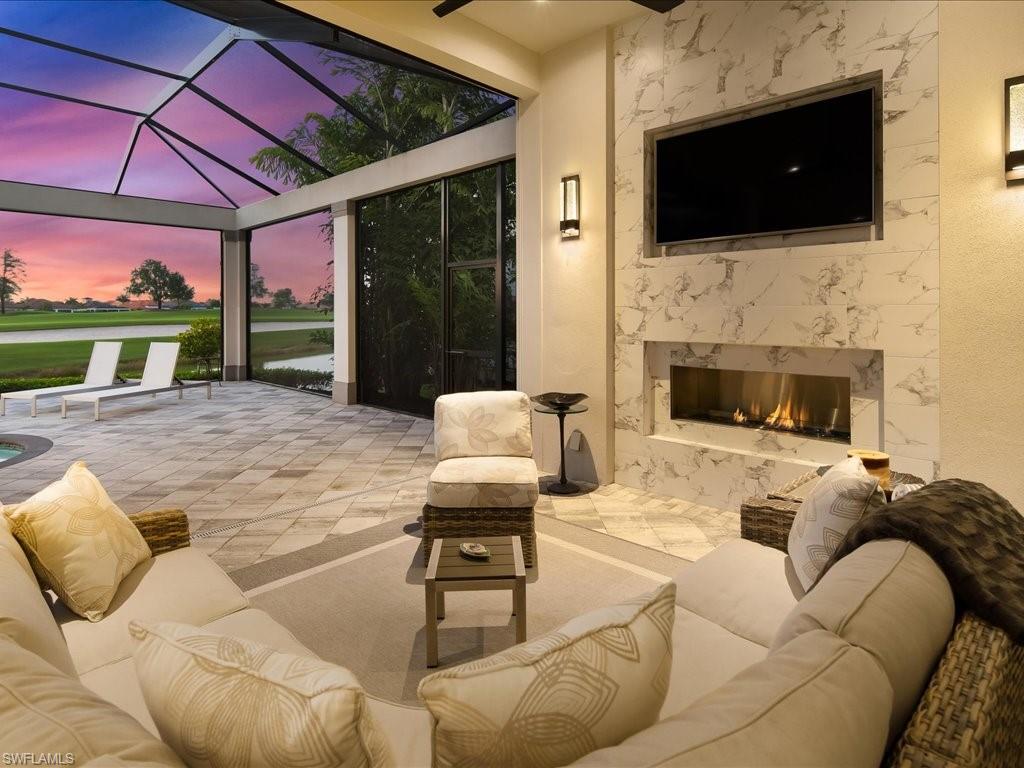 16337 Corsica Way Naples, FL 34110 - Photo 32 of 47 a living room with furniture fireplace and flat screen tv