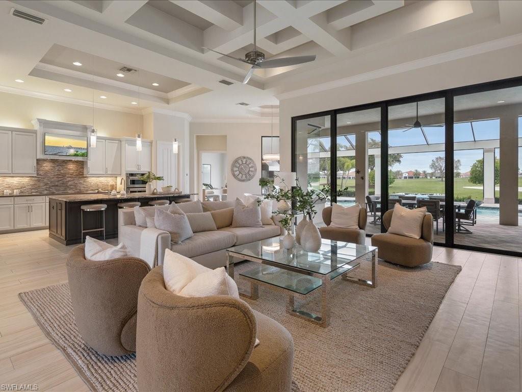 16337 Corsica Way Naples, FL 34110 - Photo 6 of 47 a living room with fireplace furniture and a large window