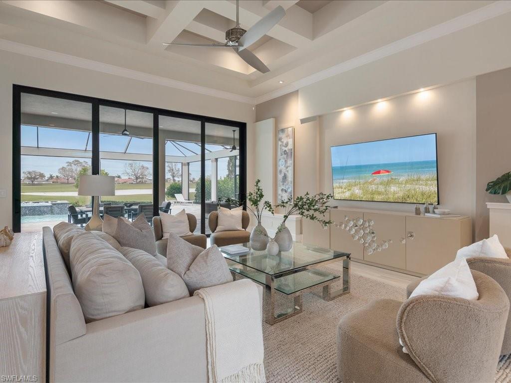 16337 Corsica Way Naples, FL 34110 - Photo 7 of 47 a living room with furniture large windows and a flat screen tv