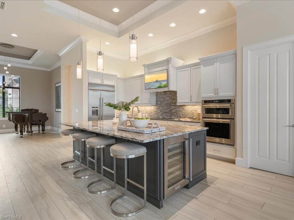 16337 Corsica Way Naples, FL 34110 - Photo 9 of 47 a kitchen with stainless steel appliances granite countertop a stove and a refrigerator