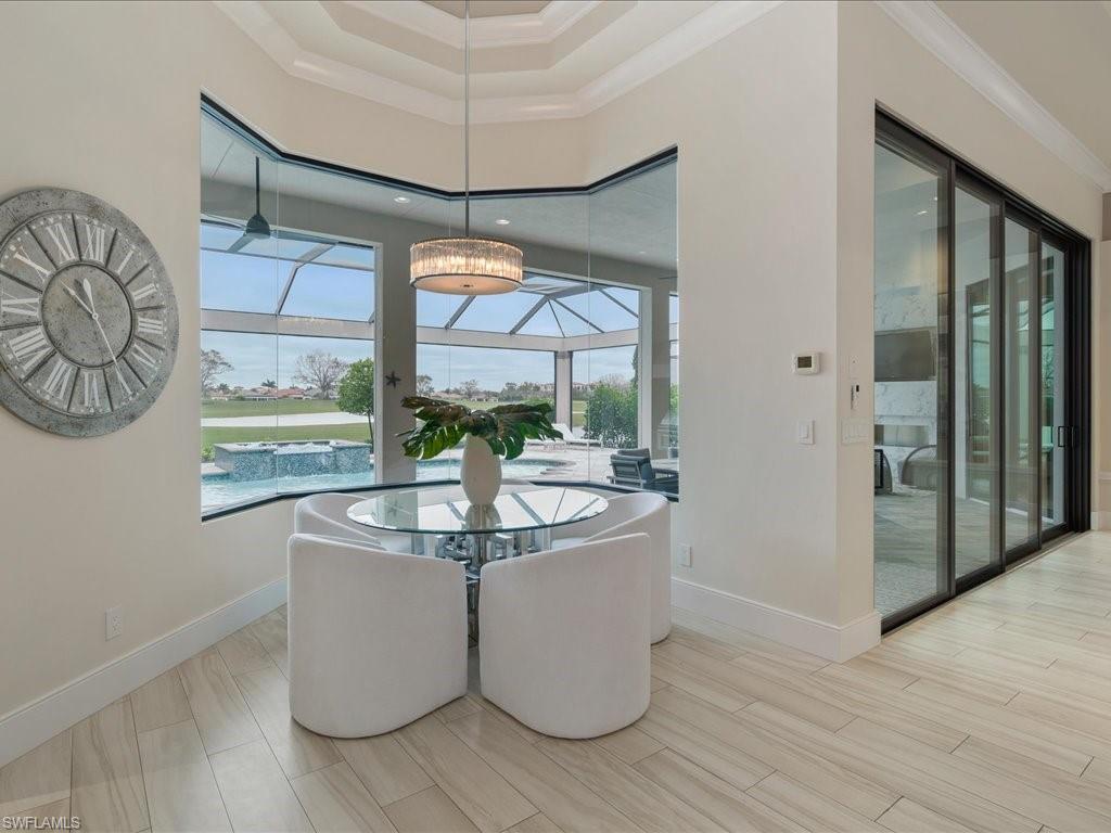 16337 Corsica Way Naples, FL 34110 - Photo 10 of 47 a dining room with wooden floor table and chairs