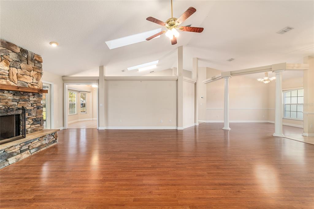 9611 Southwest 45th Avenue Ocala, FL 34476 - Photo 7 of 56 a view of an empty room with wooden floor and a fireplace