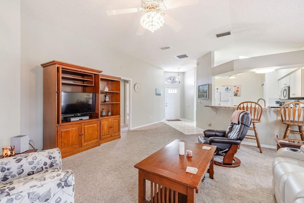 6555 Wilander Street Leesburg, FL 34748 - Photo 11 of 45 a living room with furniture and a flat screen tv
