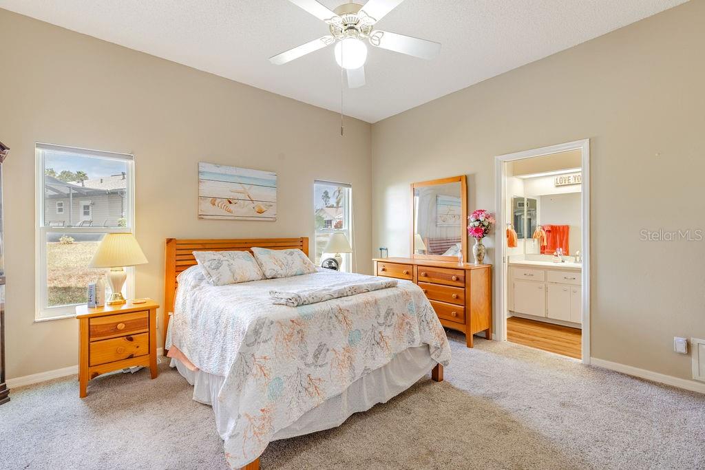 6555 Wilander Street Leesburg, FL 34748 - Photo 19 of 45 a bedroom with a bed and a chandelier
