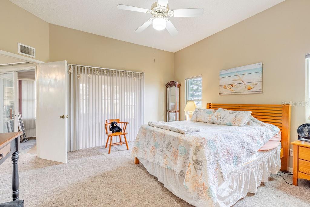 6555 Wilander Street Leesburg, FL 34748 - Photo 20 of 45 a bedroom with a bed and a chandelier