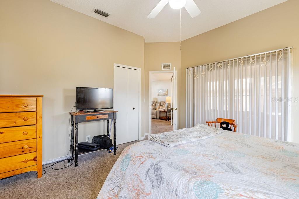 6555 Wilander Street Leesburg, FL 34748 - Photo 21 of 45 a bedroom with a bed and a television