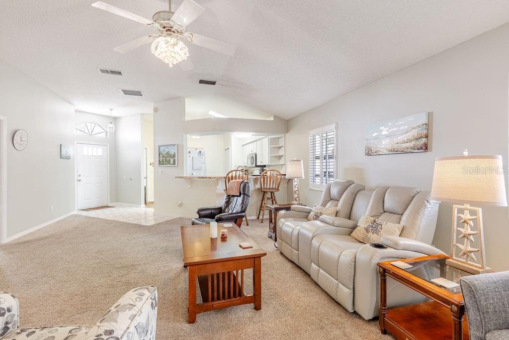 6555 Wilander Street Leesburg, FL 34748 - Photo 10 of 45 a living room with furniture a chandelier and a couch
