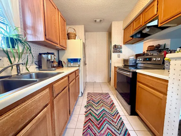 a kitchen with stainless steel appliances granite countertop a sink a stove and a refrigerator