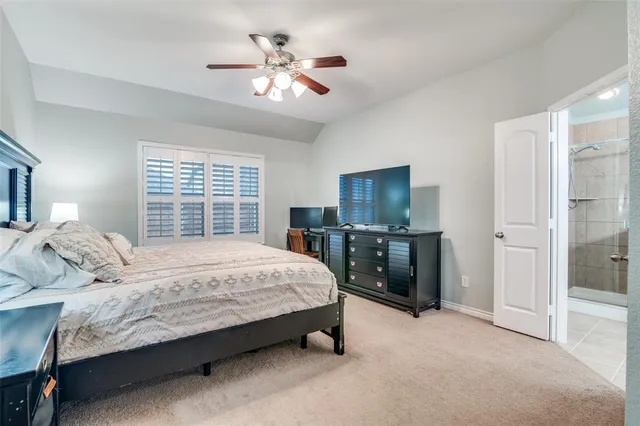 a spacious bedroom with a bed and a chandelier
