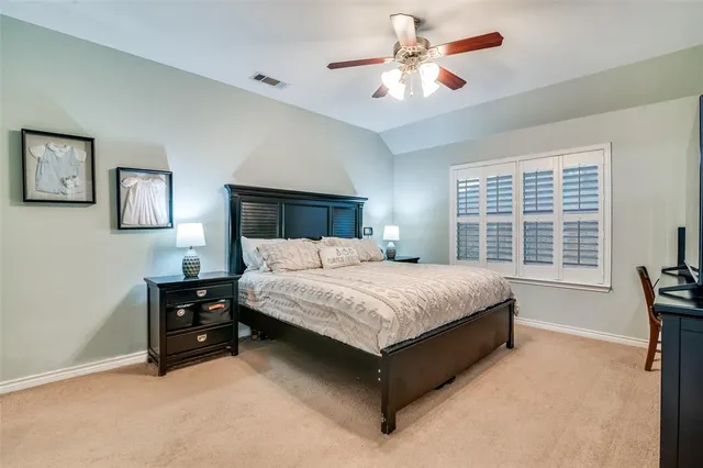 a bedroom with a bed dresser and a large window
