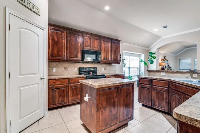 a kitchen with stainless steel appliances granite countertop a stove top oven a sink dishwasher and a refrigerator