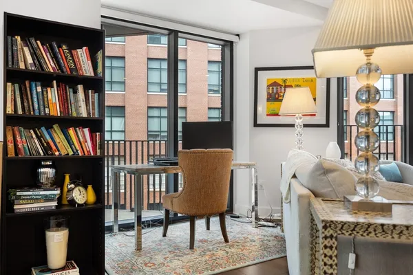 a view of a workspace with furniture and a book shelf