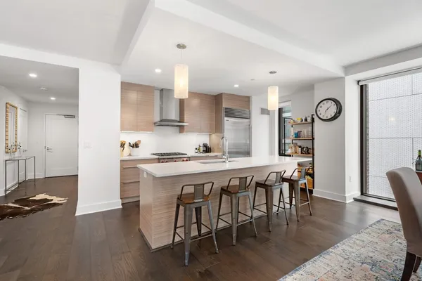 an open kitchen with granite countertop a stove and white cabinets