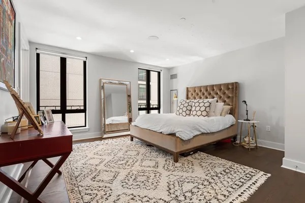 a bedroom with a bed rug and wooden floor