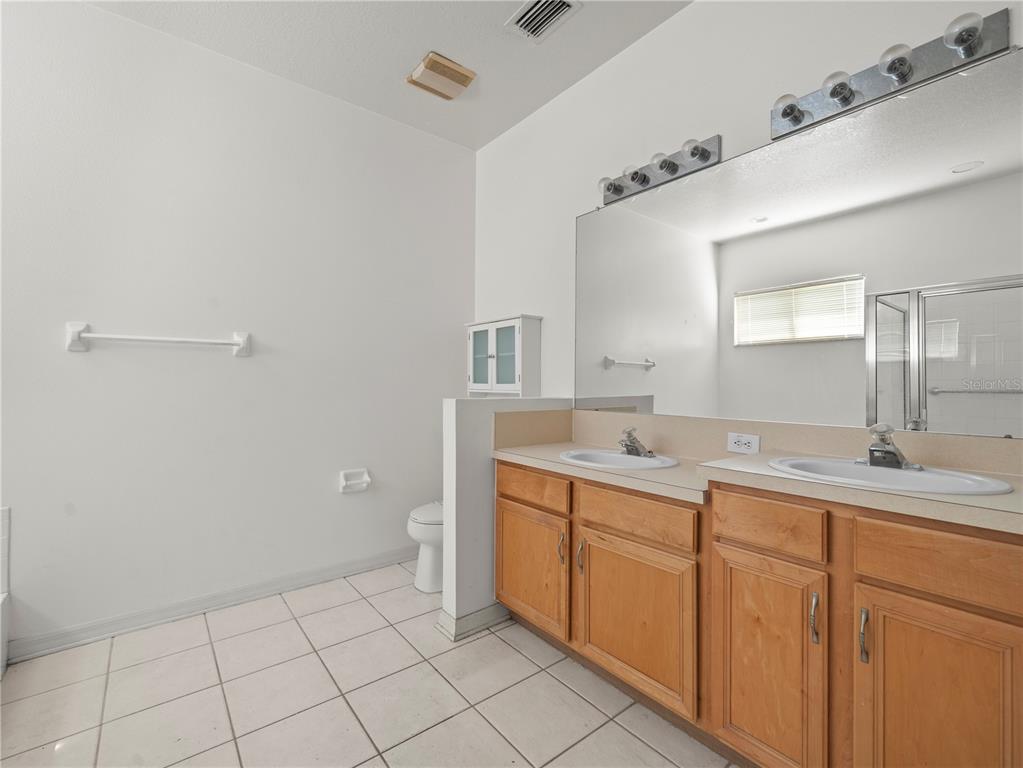 30638 Nickerson Loop Wesley Chapel, FL 33543 - Photo 20 of 39 a spacious bathroom with a granite countertop sink and a mirror