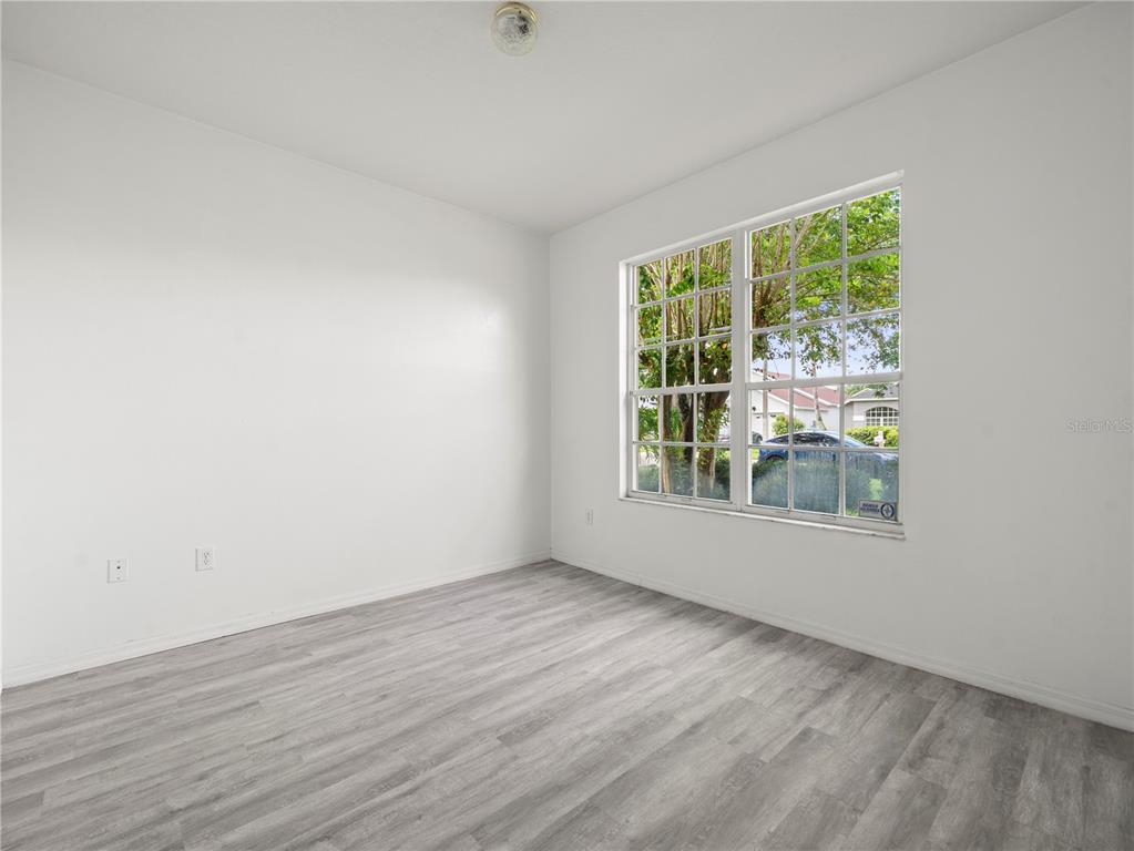 30638 Nickerson Loop Wesley Chapel, FL 33543 - Photo 22 of 39 a view of an empty room with wooden floor and a window