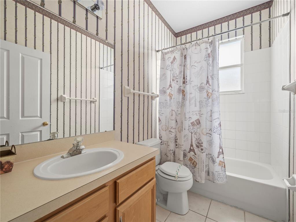 30638 Nickerson Loop Wesley Chapel, FL 33543 - Photo 27 of 39 a bathroom with a granite countertop sink toilet a mirror and shower
