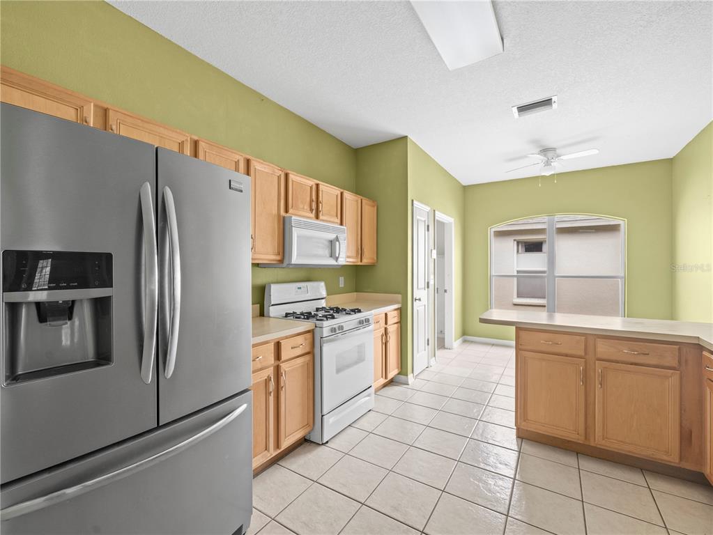 30638 Nickerson Loop Wesley Chapel, FL 33543 - Photo 10 of 39 a kitchen with stainless steel appliances granite countertop a refrigerator and a stove top oven