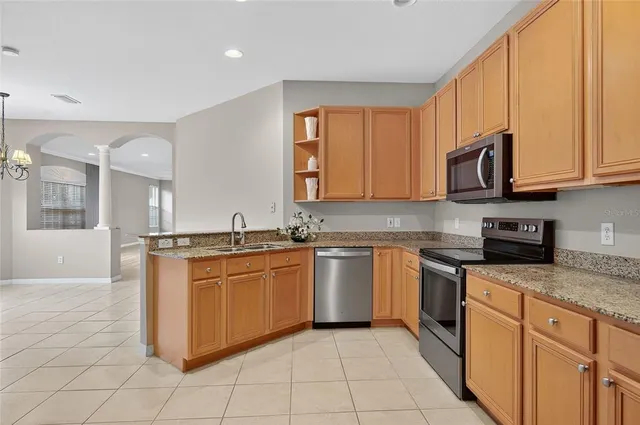 a kitchen with stainless steel appliances granite countertop a stove sink and microwave