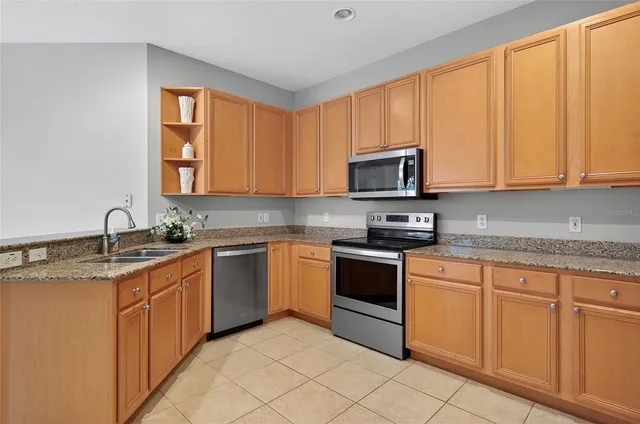 a kitchen with stainless steel appliances granite countertop a refrigerator stove and sink